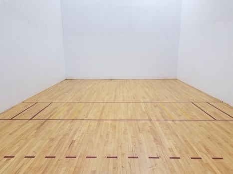 wood floor on racketball court with white walls