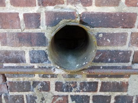 metal pipe or tube in red brick wall or masonry