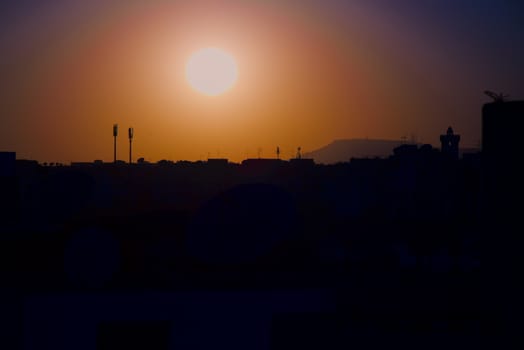 sunset on the city of Agadir Morocco with antennas minaret and hill Oufella