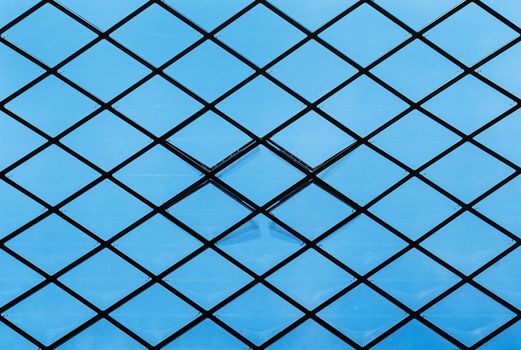Detail of an inner ceiling with transparent windows against a clear blue sky.