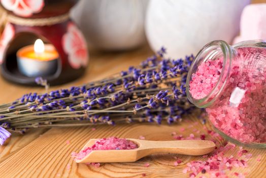 sea salt in a wooden spoon with natural lavender oil and a bunch of dried flowers spa with lavender