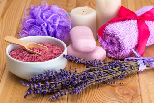 bunch of dried lavender flowers, pink soap and sea salt with lavender aroma, spa objects close up