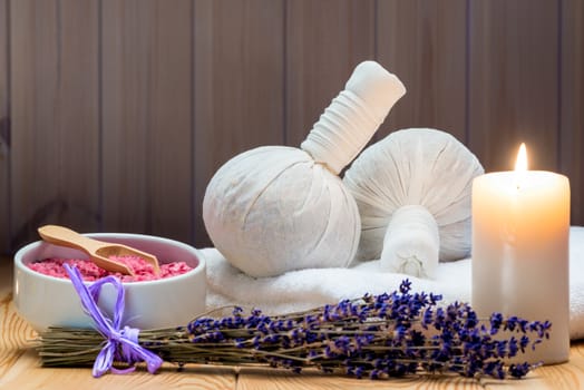 herbal bags with natural lavender and sea salt with a burning candle for a spa, relaxation and romantic atmosphere
