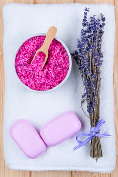 dried lavender on a white terry towel, sea salt and two bars of soap for spa objects top view