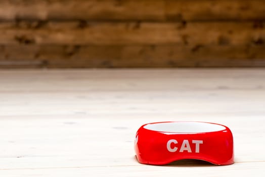 Cat red bowl empty on the floor in the house, the space on top