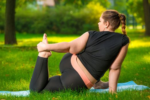 fat woman in the park doing yoga, plus size woman is very flexible and strong