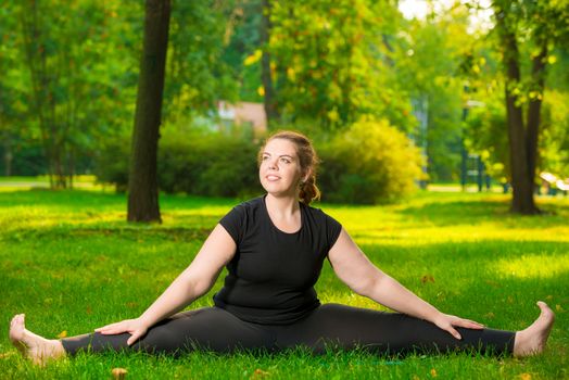 happy woman oversize flexible stretched on a lawn sitting on a string