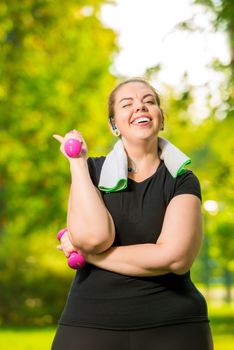 30 years old plus size woman doing dumbbells during a summer park workout