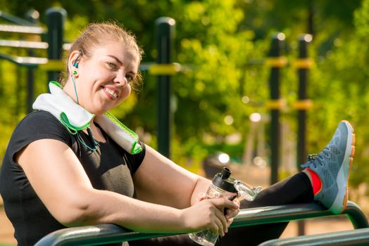 flexible plus size woman engaged with a port on the playground in a park on a summer morning