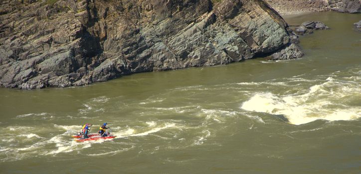 A group of people on rafting overcome the rapids of the mountain river Katun. Altai, Siberia, Russia.