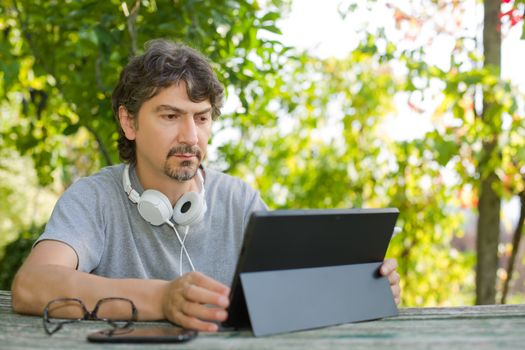 casual man working with a tablet pc, outdoor