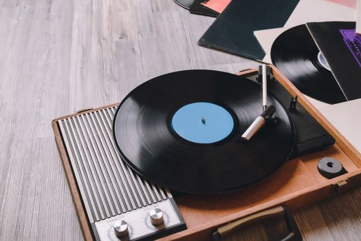 Vintage Gramophone with a vinyl record on gray wooden table, top view and copy space.