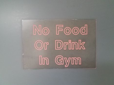 no food or drink in gym sign on black wall or surface