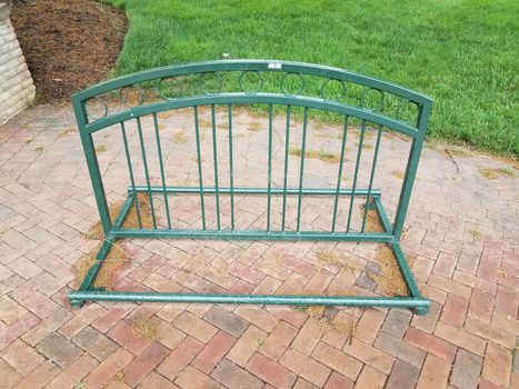 green metal bike or bicycle rack and red bricks or masonry