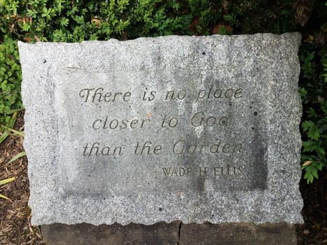 there is no place closer to God than the garden quote on grey stone or rock