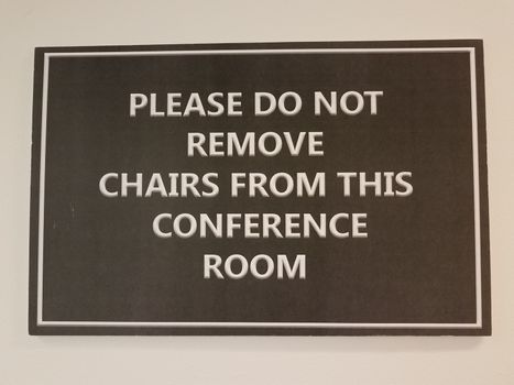 black please do not remove chairs from this conference room sign on white wall