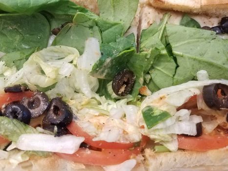 sandwich bread with olives and tomato, spinach, and lettuce