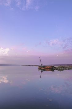 Panoramic view of the clouds above the water in a pink and purple sunset