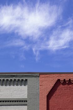 Decorative brickwork is seen along the rooflines of buldings against cirrus clouds.
