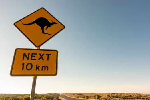  kangaroo crossing road sign warning drivers in  Australia