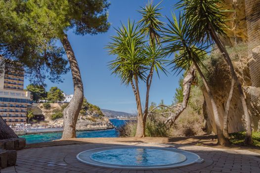 Outdoor Jacuzzi above the Mediterranean Sea between palm trees