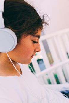 She seats outside in the garden, wearing headphones.