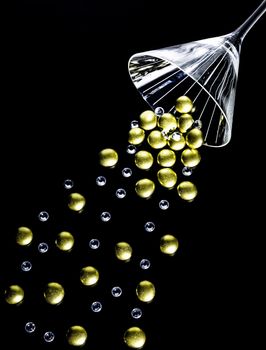 Golden nuggets and crystals spilling out of a martini glass.