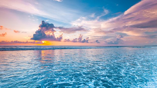 Amazing colorful sunset over sea form Bali beach and majestic cloudscape