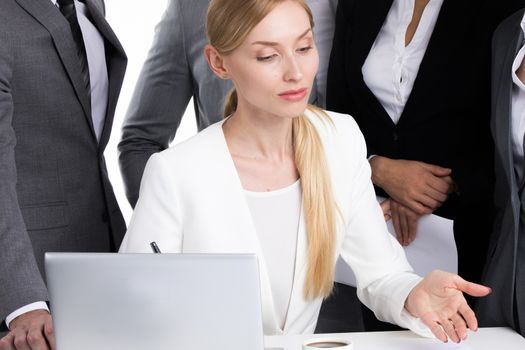 Female business leader talking to coworkers at meeting