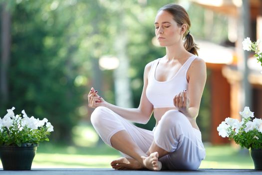 Young woman practicing yoga lotus exercise outdoors