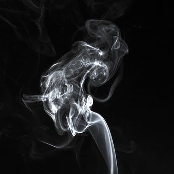 Abstract white smoke swirls over the black background