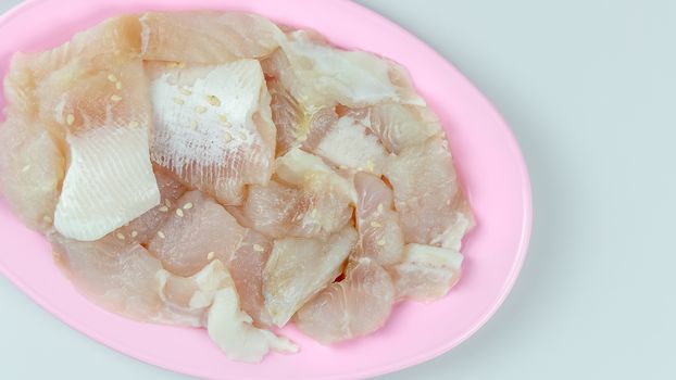 top view raw  fish with white sesame seed on plate on white background