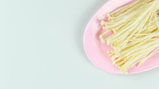 top view fresh Golden Needle Mushroom on pink plate with copy space