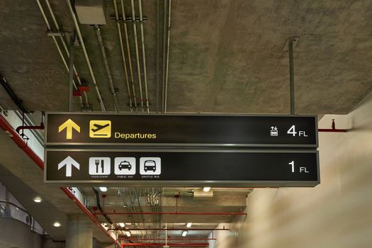 Departure guide information board sign with yellow and food court with transport white character on black background at international airport terminal.