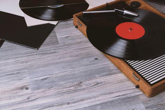 Turntable vinyl record player on the background of their gray wooden boards. Needle on a vinyl record. Black vinyl record,Sound technology for DJ to mix & play music.