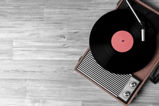 Vintage turntable with a vinyl record on gray wooden table, top view and copy space.desaturate photo.