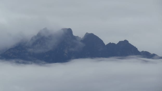 A beautiful view of the Himalayan moutain peaks rising above the clouds in Asia.