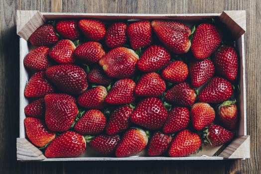 wooden box with strawberries on a wooden table, top view point, healthy sweet food, vitamins and fruity concept .Food frame background, flat lay