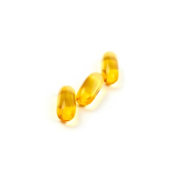 Close up three yellow Omega 3 vitamins and essential fish oils gel cap pills isolated on white background, high angle view