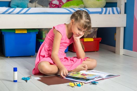 The girl with interest leafs through the book of creativity