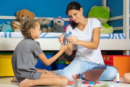 Mom and daughter stick a mouse figure