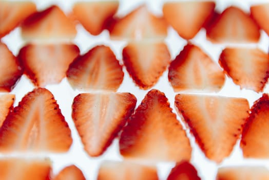 sliced fresh strawberries isolated on white background, neatly arranged slices of red strawberry on a white table, healthy sweet food, vitamins and fruity concept