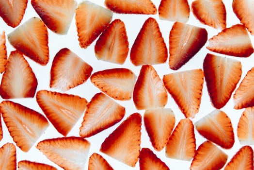 sliced fresh strawberries isolated on white background, messy arranged slices of red strawberry on a white background, healthy sweet food, vitamins and fruity concept, top view