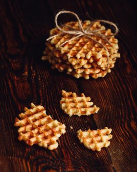Stack of Belgian Waffles and Waffle Pieces on Wooden Surface. Vertical Orientation.