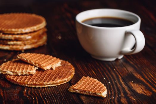 Dutch Waffles with White Cup of Coffee and Waffle Stack on Backdrop.