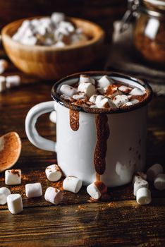 Cocoa Mug with Marshmallows. Jar of Cocoa Powder and Marshmallow Bowl on Backdrop. Vertical Orientation.