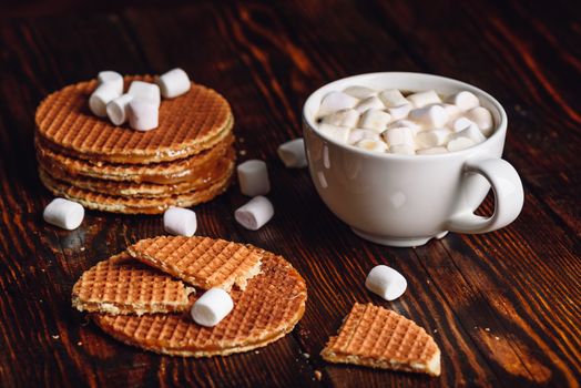 Broken Dutch Waffles with White Cup of Coffee with Marshmallow and Waffle Stack.