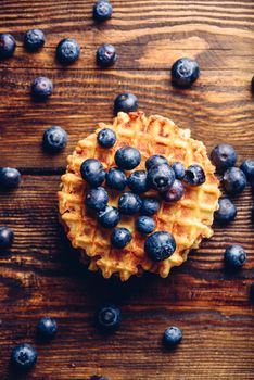 Blueberries on the Top of the Waffle and Other Scattered on Wooden Background. Vertical Orientation.