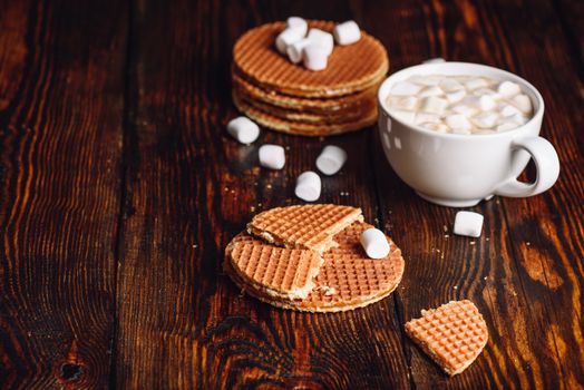 Stroop Waffles with Broken One with White Cup of Hot Chocolate with Marshmallow and Waffle Stack. Copy Space on the Left.