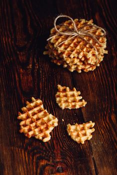 Stack of Waffles and Waffle Pieces on Wooden Surface. Vertical Orientation.